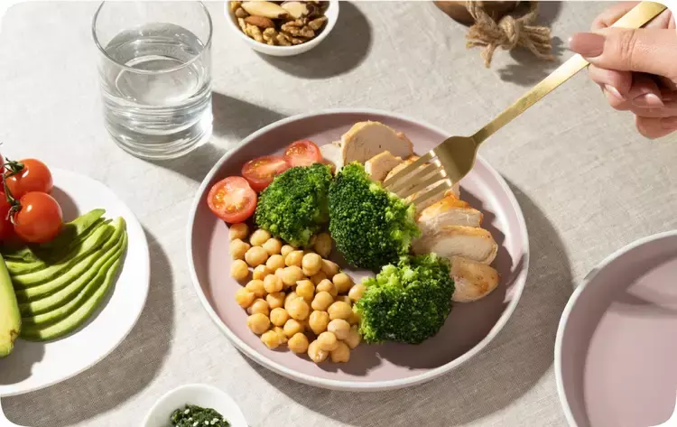 A salad with fork and glass of water aside.