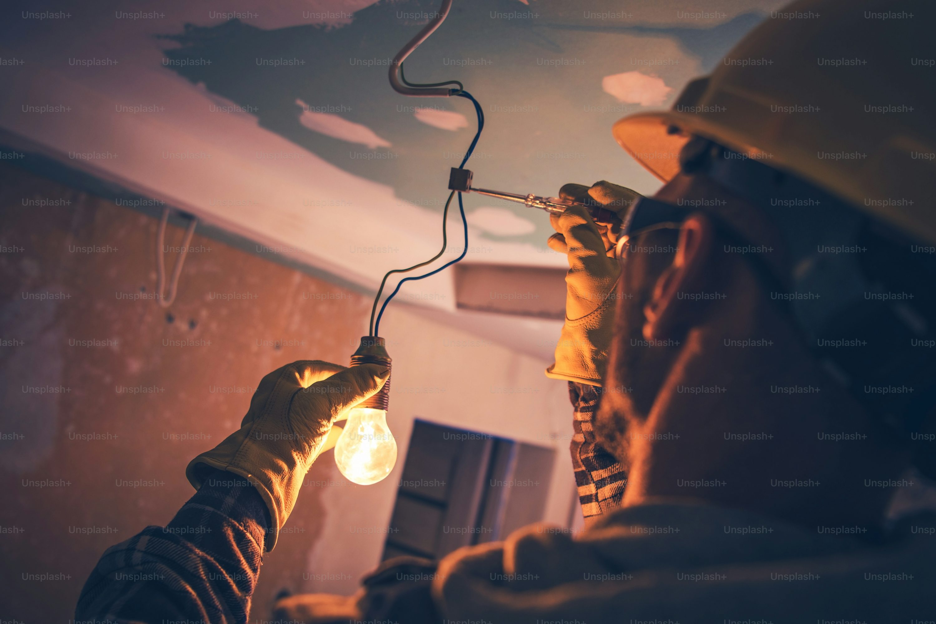 Electrician repairing ceiling wiring with bulb fitting – Homizon expert electrical services