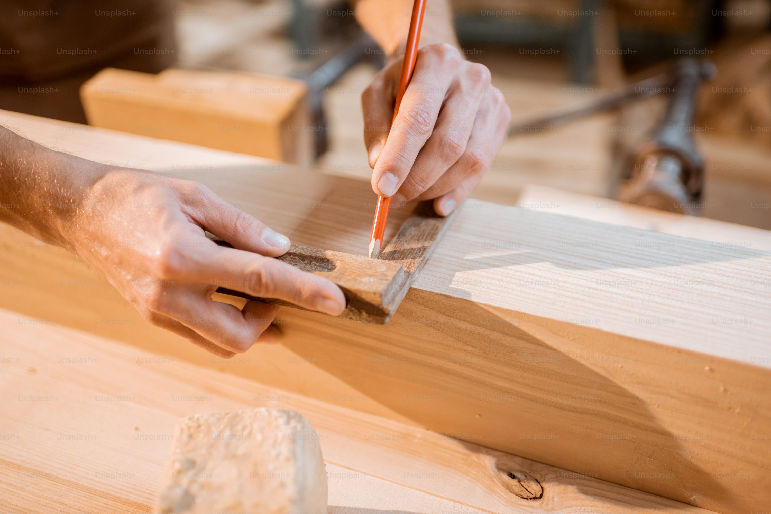 Carpenter smoothing wooden plank during furniture work Homizon carpentry solutions