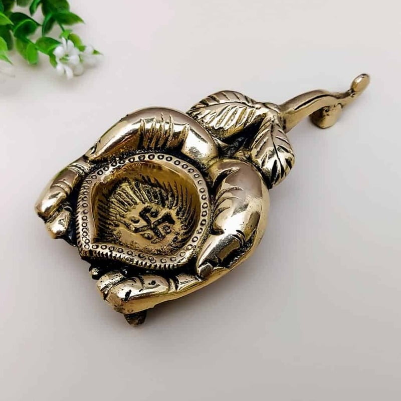 Brass Diya holding in Hands - 1 inch Height | Elegant Brass Diya held in Hands for Lighting Brass Diya holding in Hands - 1 inch Height | Elegant Brass Diya held in Hands for Lighting